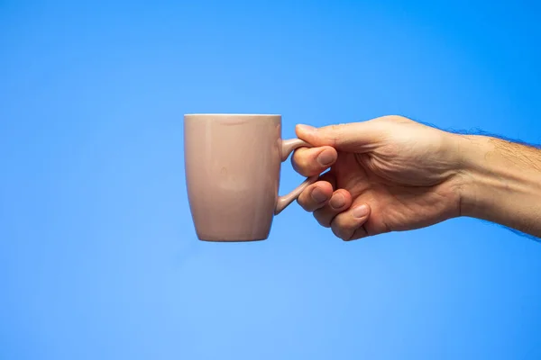 Blanke Mannelijke Hand Met Keramische Generieke Koffiemok Geïsoleerd Blauwe Achtergrond — Stockfoto