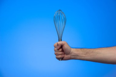 Mavi arka planda gümüş metal bıyıklı beyaz erkek eli var..