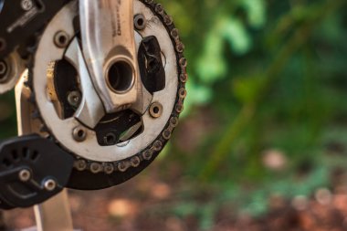 Mountain bike used and dirty front crank drive and link chain close up shot outside.