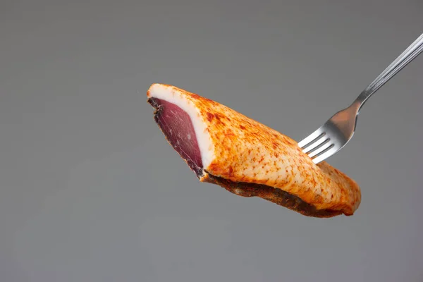 Tütsülenmiş kaz göğsü. Stüdyoyu kapat. Gri arka planda izole edilmiş..