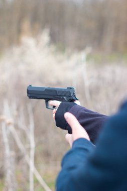 Genç kadın kolları ve elleri nefsi müdafaa taliminde silah doğrultuyor..