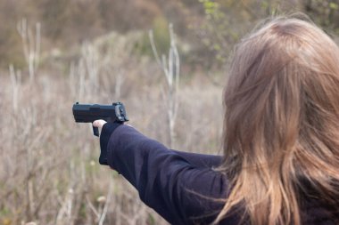 Genç kadın kolları ve elleri nefsi müdafaa taliminde silah doğrultuyor..