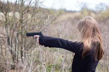 Genç kadın kolları ve elleri nefsi müdafaa taliminde silah doğrultuyor..