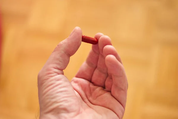 Mão Masculina Caucasiana Segurando Uma Pílula Médica Entre Dedos Profundidade — Fotografia de Stock