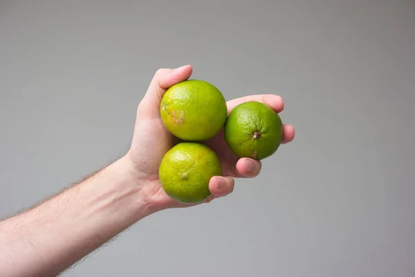 Limes Verdes Frescos Realizada Mão Por Caucasiano Macho Fechar Estúdio — Fotografia de Stock