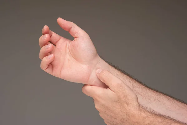 Mãos Masculinas Caucasianas Verificar Pulso Cardíaco Pulso Isolado Fundo Marrom — Fotografia de Stock