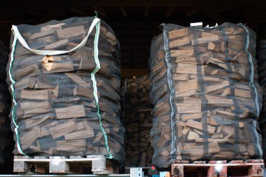Ahşap paletlerin üstüne örülmüş odun yığını. Düşük açı, insan yok..