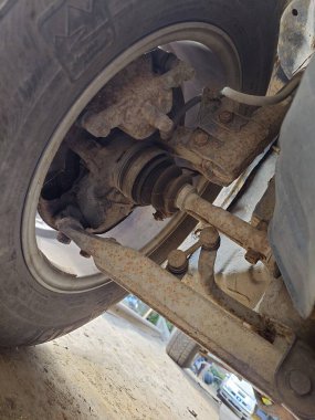 Genel arabanın paslı ön süspansiyon bileşenleri. Düşük, zemin kat, geniş açı, insan yok.