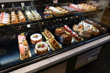 Delft, Hollanda, 28 Ağustos 2025. Bir pastanenin soğutuculu vitrininde taze hamur işleri ve keklerden oluşan bir seçim..