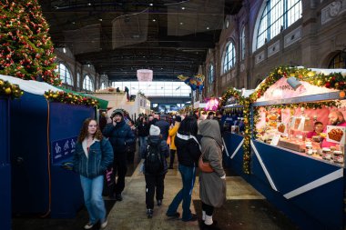 Zürih HB, İsviçre, 20 Kasım 2025. İnsanlar ana salondaki yiyecek, içecek ve hediyelik eşya dükkanlarını ya da mağazaları ziyaret ediyor. Geniş açı görünümü