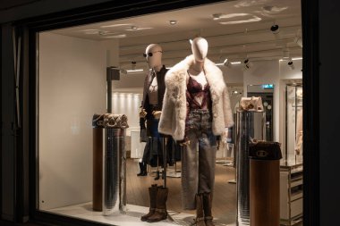 Zürih, İsviçre, 26 Kasım 2025. Liu Jo vitrininde şık kıyafetler giymiş kadın mankenler var. Aydınlatılmış dükkan penceresi, gece fotoğrafı, insan yok.