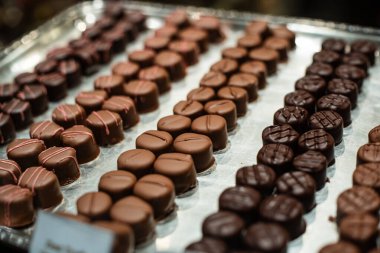 Vitrindeki el yapımı çikolatalı trüf ve pralinlerin çeşitliliği. Kapat, kimse yok.