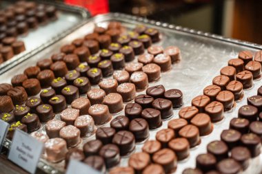 Vitrindeki el yapımı çikolatalı trüf ve pralinlerin çeşitliliği. Kapat, kimse yok.