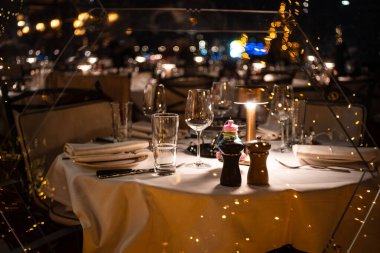 Zürih, İsviçre, 17 Aralık 2025. Gece şık bir restoranda şık bir yemek masası. Geniş açı, yakın çekim, sığ derinlik, insan yok.