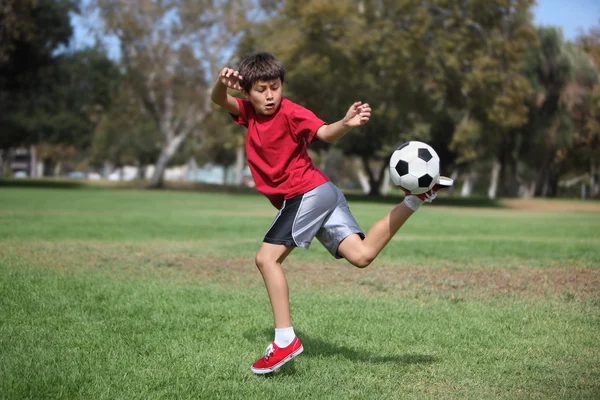 Futbol topu parkta genç çocukla — Stok fotoğraf