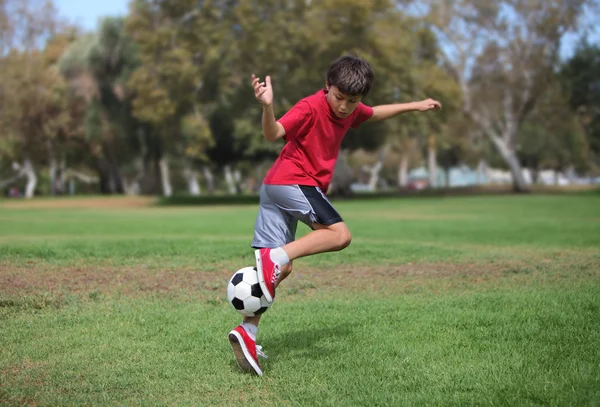 Jeune garçon avec ballon de football dans le parc — Photo