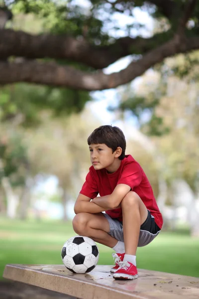 Niño en el parque con pelota de fútbol — Foto de Stock