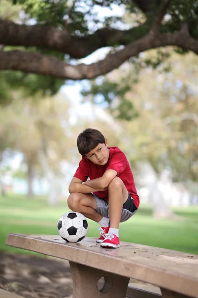 Chlapec v parku s fotbalovým míčem — Stock fotografie