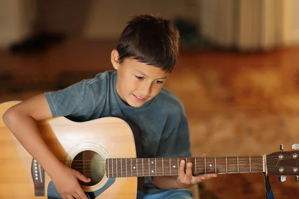 Ung pojke spelar en gitarr — Stockfoto