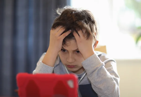 Giovane ragazzo confuso guardando tablet — Foto Stock