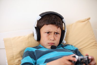 Genç çocuk kulaklık ve mikrofon vieo oyun oynuyor