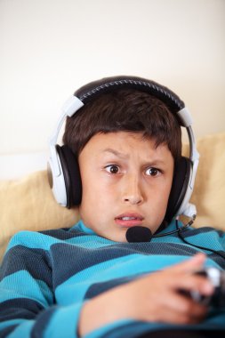 Genç çocuk kulaklık ve mikrofon vieo oyun oynuyor