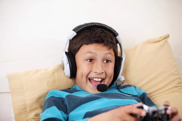 Jeune garçon jouant jeu vieo avec écouteurs et microphone — Photo