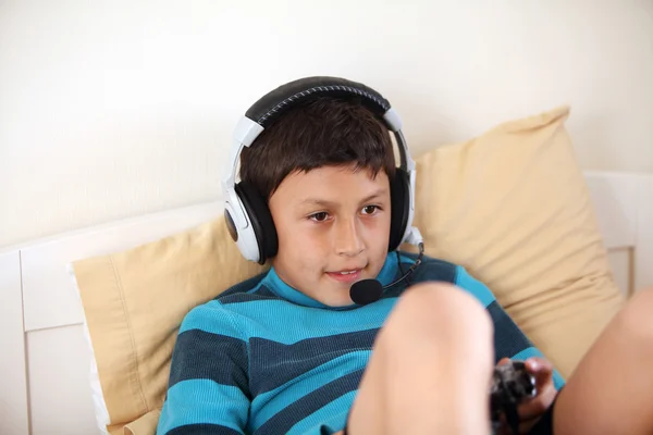 Young boy playing vieo game with headphones and microphone Stock Photo