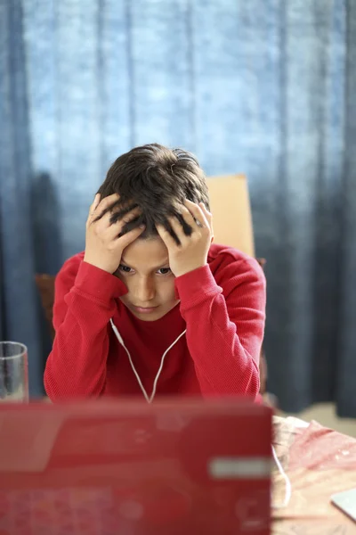 Young boy looks confused while doing his homework — Stock Photo, Image