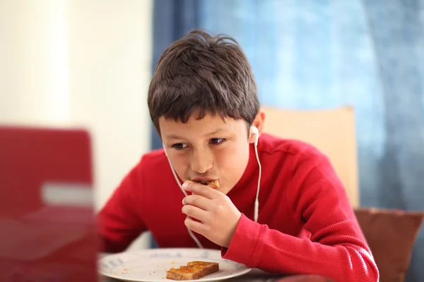 Мальчик ест тосты на завтрак — стоковое фото