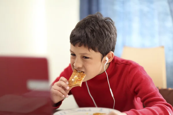 Ung pojke äta frukost toast — Stockfoto