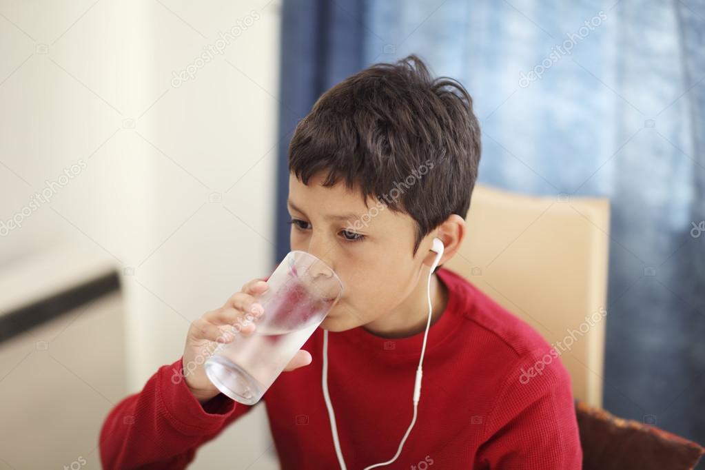 Young boy drinking from a glass of water