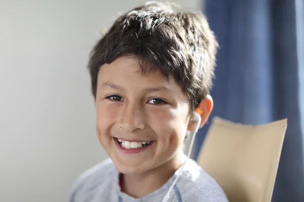 Молодой улыбающийся мальчик с наушниками — стоковое фото