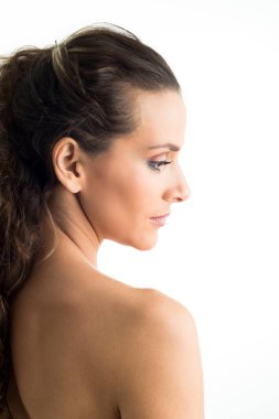 Beyaz arka planda saçları toplanmış genç bir kadının portresi.