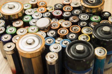 Ahşap bir masaya düzgünce yerleştirilmiş bataryalar. Geri dönüşüm ve çevre bakımı kavramı.