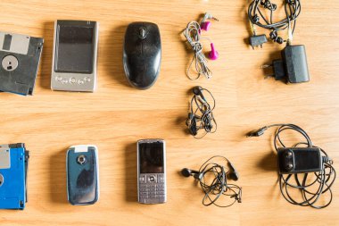 Eski elektronik ve teknolojik nesneler parke zemine dizilmiş. Teknolojik atıklar ve geri dönüşümü, çevreye bakılması gereken sorunlardan biri..