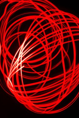 Siyah zemin üzerindeki kırmızı çizgilerin deseni bir fenerin ışığıyla boyanmış..