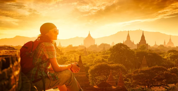 Vrouw backpacker op zonsondergang zitten en genieten van het uitzicht. — Stockfoto