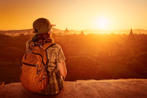 Kadın turist günbatımı üzerinde oturmak ve manzarasının tadını çıkarın. — Stok fotoğraf