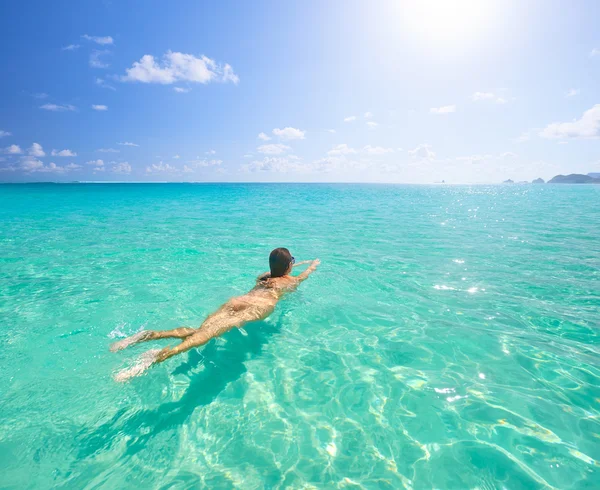 Young woman swimming in transparent tropical sea. Royalty Free Stock Images