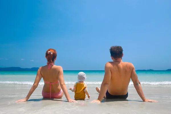 Visão traseira de uma família feliz em uma praia tropical — Fotografia de Stock