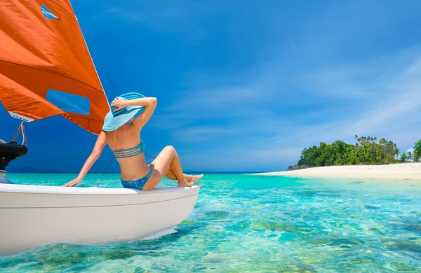 Mujer viajero sentarse en la popa de velero mirando a la playa —  Fotos de Stock