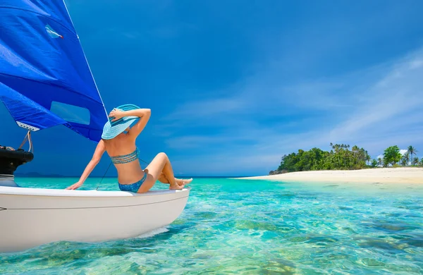 Woman traveler sit at the stern of sailboat looking to the beach — Stock Photo, Image