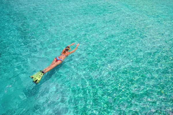 Mulher de maiô está nadando com snorkel e barbatanas em uma wa azul — Fotografia de Stock