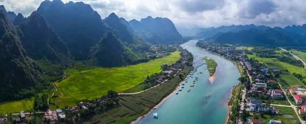 Flygfoto över Phong Nha stad och Son floden i bakgrunden av bergen i Quang Binh-provinsen, Vietnam Stockbild