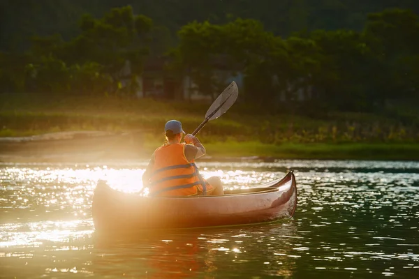 Woman in life jacket swims on kayak on river in countryside Stock Image