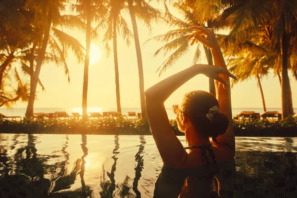 Vacaciones Playa Verano Concepto de vacaciones. Silueta mujer joven que se relaja en la piscina en el complejo de playa de verano viendo la puesta de sol Fotos De Stock