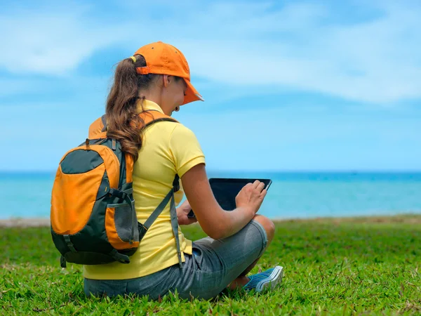 Sidovy av ung kvinna på gräsmattan med sin tablet PC — Stockfoto