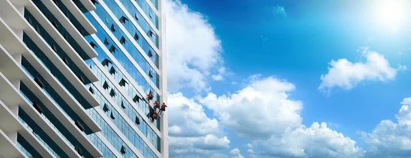 Grupo de trabalhadores de limpeza de janelas no edifício alto — Fotografia de Stock