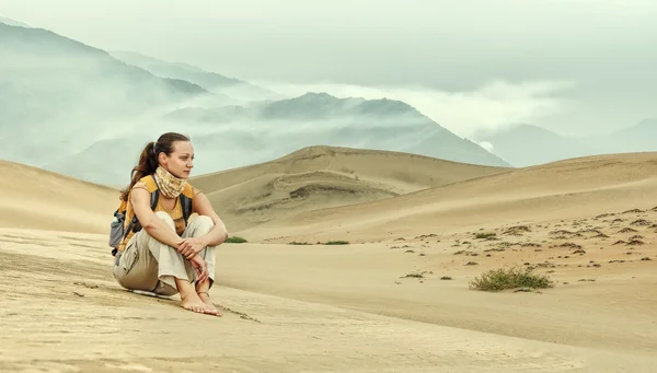 Молодая женщина сидит и смотрит на пустынную долину . — стоковое фото